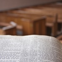 A bible in a church pulpit overlooking the church